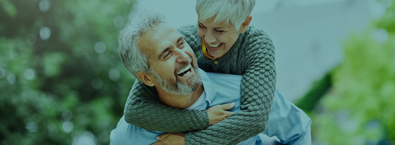 Senior man and woman laughing while hugging